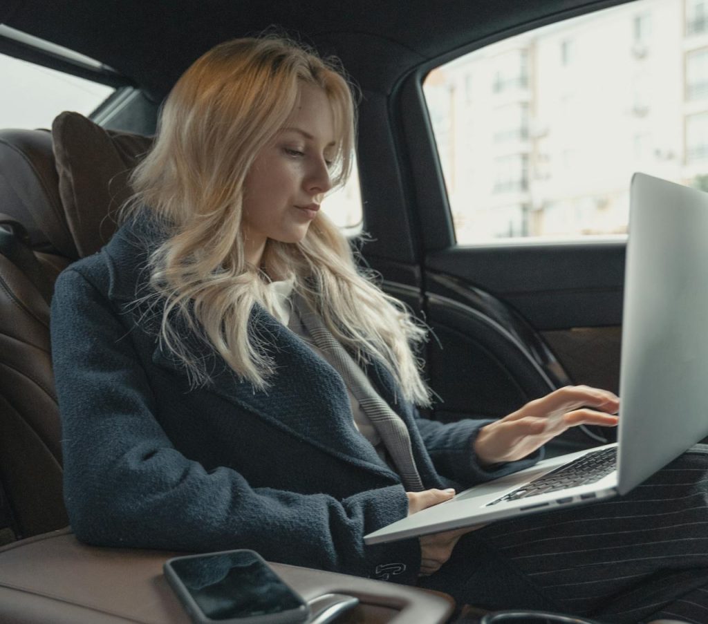 woman on laptop in car