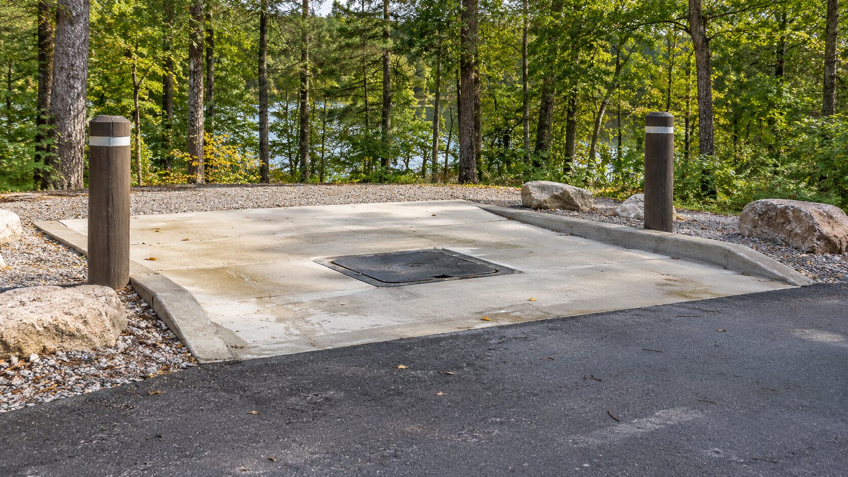 A concrete campground service pad with a closed ground-level cover.